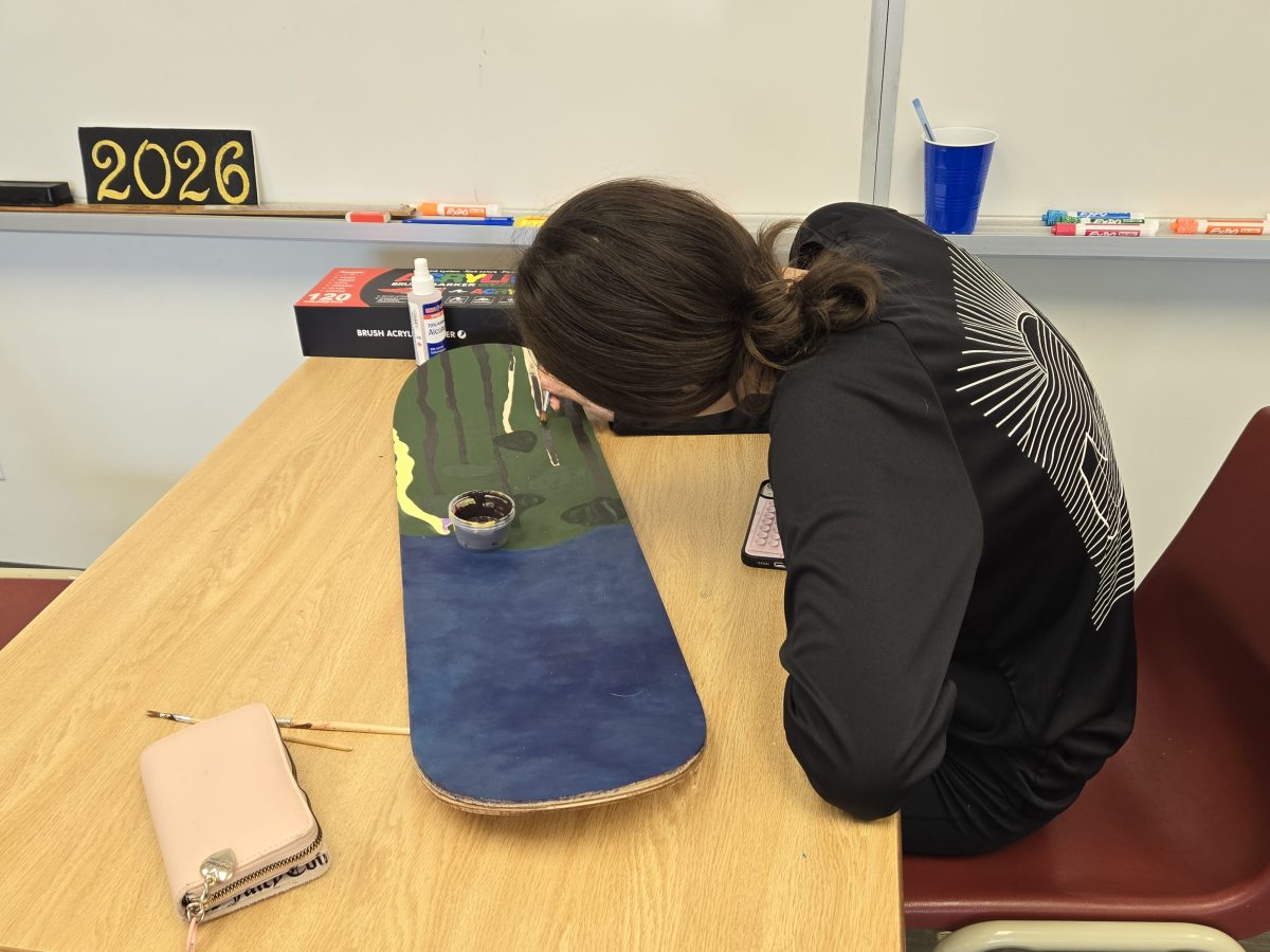 St. Don Bosco student painting a skateboard